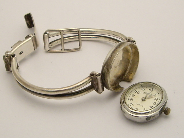 80 | Srebrny zegarek, w którym zaginęła górna część koperty.