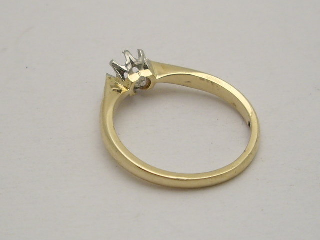 62 | Złoty pierścionek noszony z obrączką.